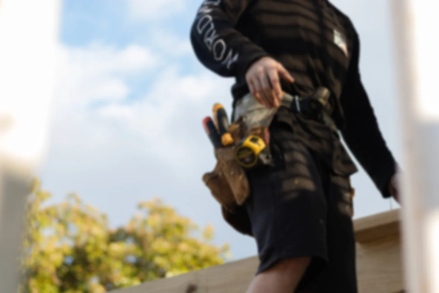 A tradesperson at work with a full tool belt